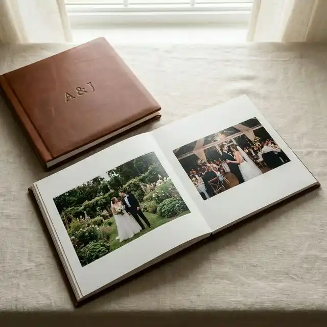 Álbum de boda abierto con páginas panorámicas mostrando fotos de ceremonia, sobre una mesa de madera