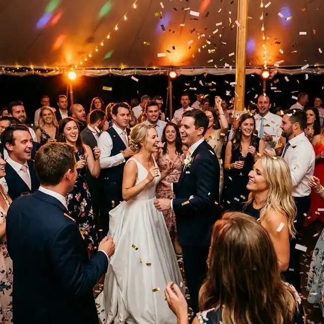 Pista de baile llena en una boda con iluminación de colores